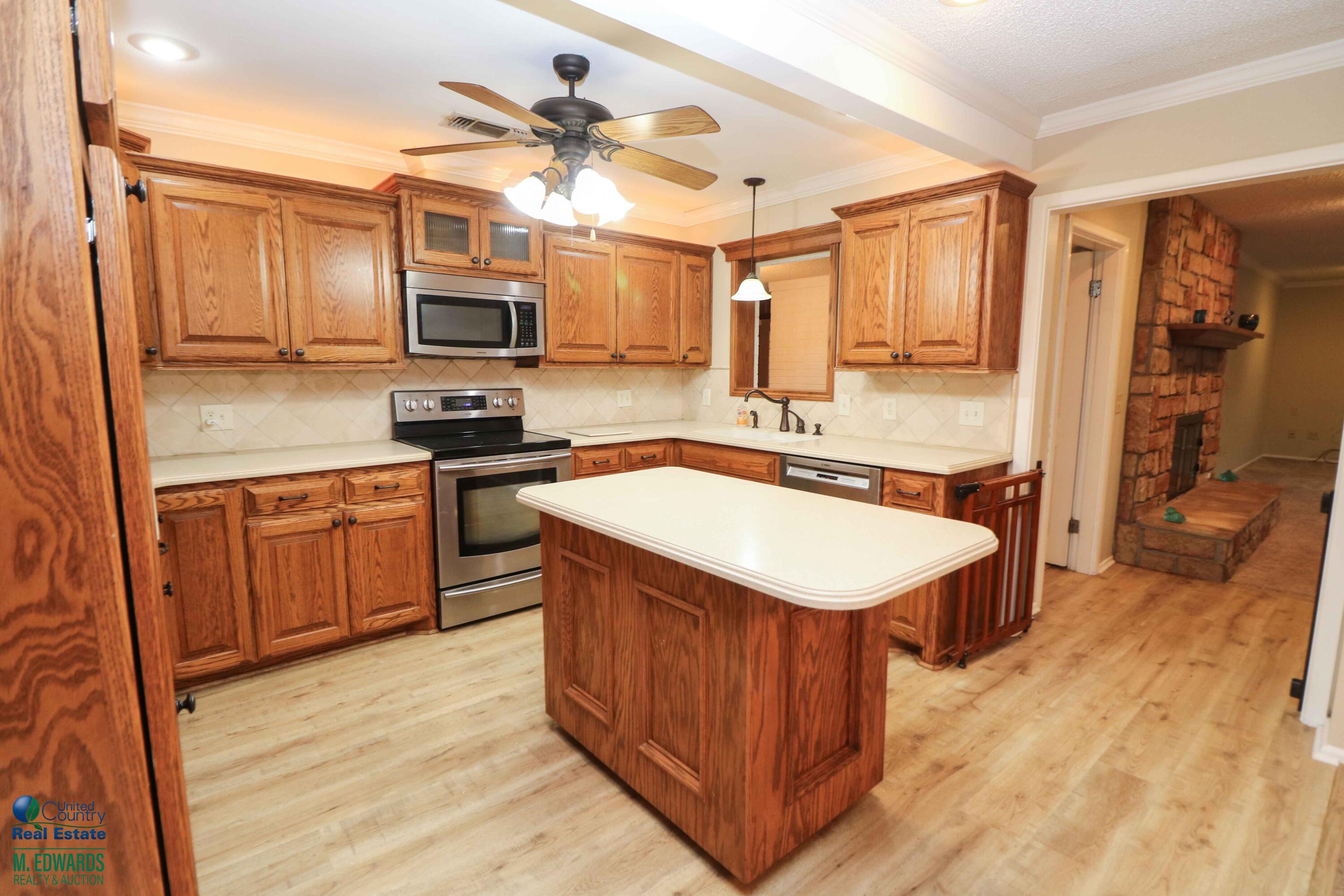 200 Crescent Drive Littlefield, TX 79339 - Photo 8 of 25 a kitchen with a sink stove and wooden cabinets