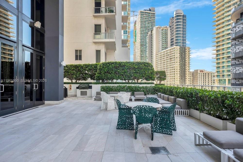 1010 Brickell Avenue, Unit 4011 Miami, FL 33131 - Photo 24 of 32 a view of a patio with a table and chairs and potted plants