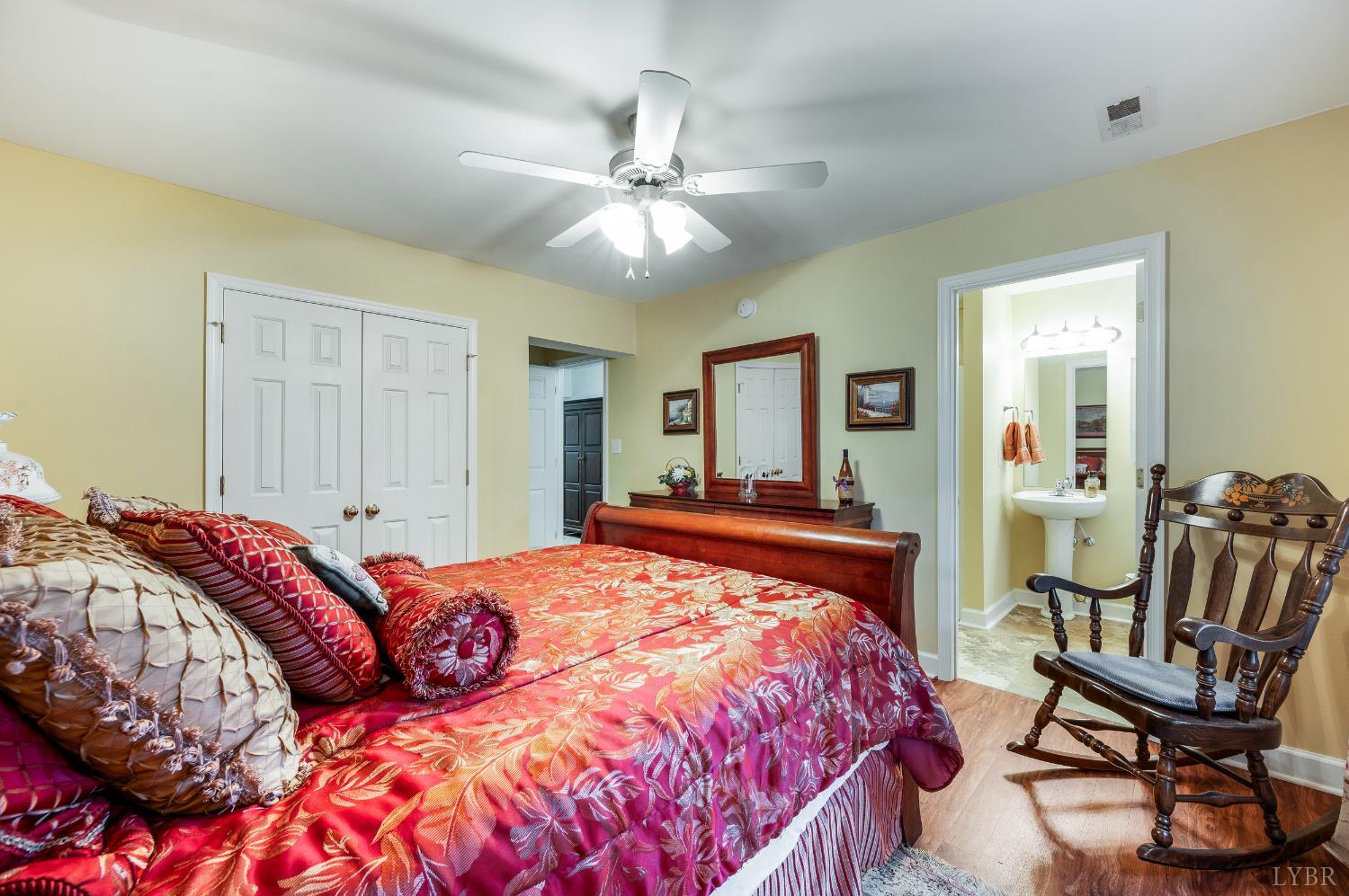 378 Tusculum Lane East Amherst, VA 24521 - Photo 60 of 99 a bedroom with a bed and a chandelier