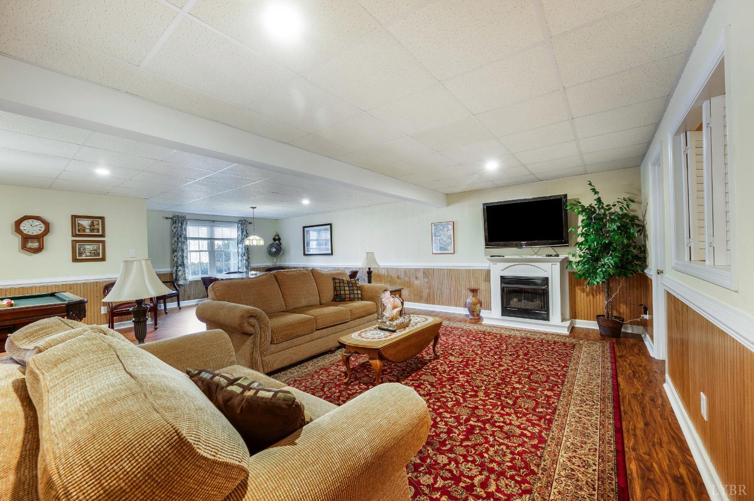 378 Tusculum Lane East Amherst, VA 24521 - Photo 68 of 99 a living room with furniture a fireplace and a flat screen tv