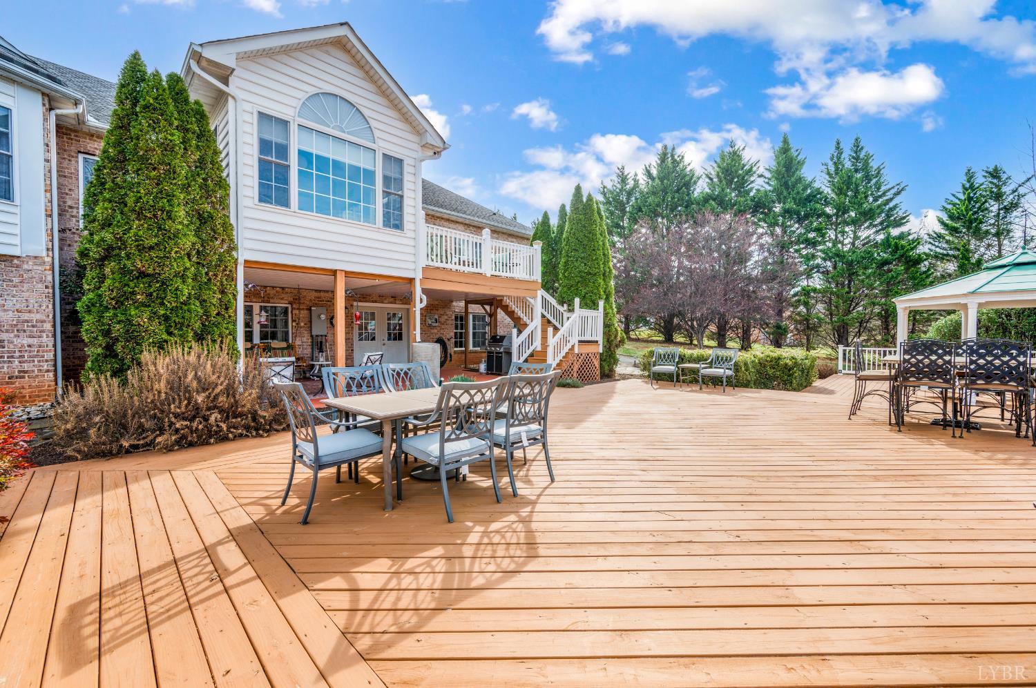 378 Tusculum Lane East Amherst, VA 24521 - Photo 79 of 99 a view of a patio with dining table and chairs with wooden floor and fence