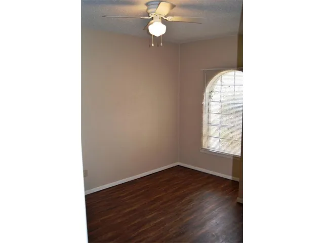 a view of a room with wooden floor and fan