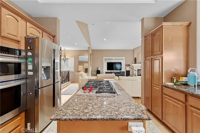 a kitchen with stainless steel appliances granite countertop a refrigerator and a stove