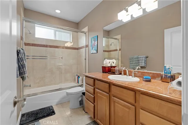 a bathroom with a bathtub shower sink vanity mirror and toilet