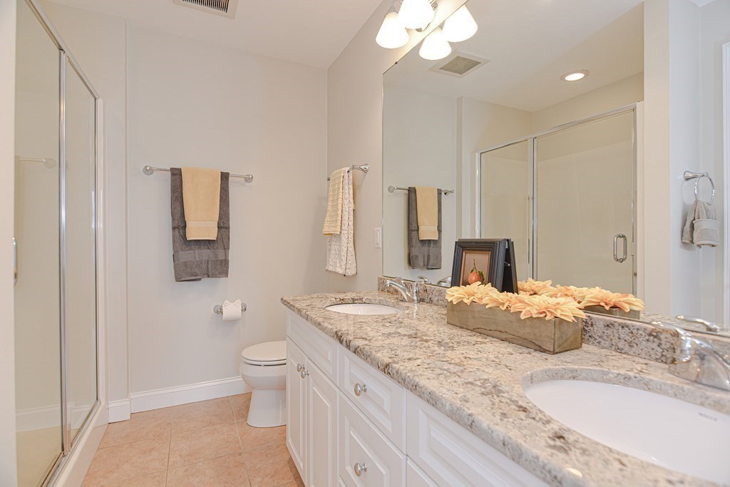 159 Prospect Street, Unit 7 Acton, MA 01720 - Photo 18 of 31 a bathroom with a granite countertop sink a toilet and large mirror