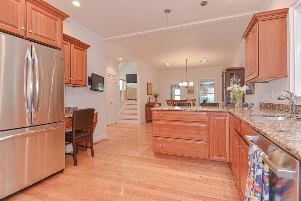 159 Prospect Street, Unit 7 Acton, MA 01720 - Photo 7 of 31 a kitchen with stainless steel appliances granite countertop a refrigerator sink and wooden cabinets