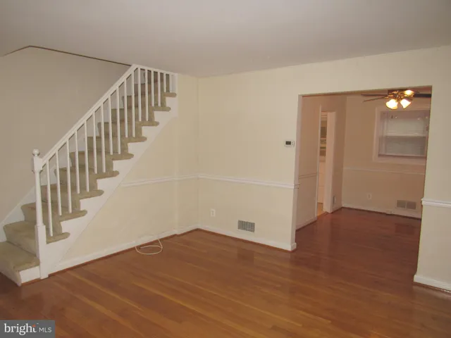 a view of an empty room with wooden floor