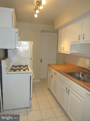 a kitchen with cabinets and white stainless steel appliances