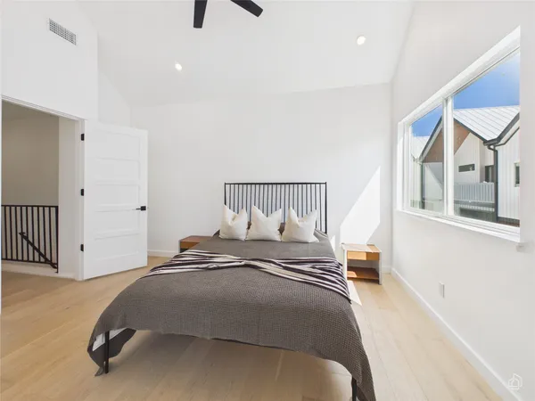 a bedroom with a bed and wooden floor