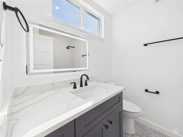 a bathroom with a sink a toilet and mirror