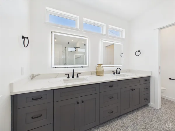 a bathroom with a double vanity sink and mirror