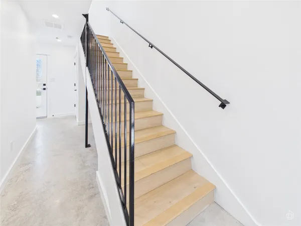 a view of staircase with white walls and railing