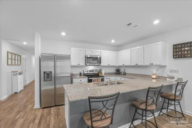 a kitchen with stainless steel appliances granite countertop a stove top oven a sink and a refrigerator