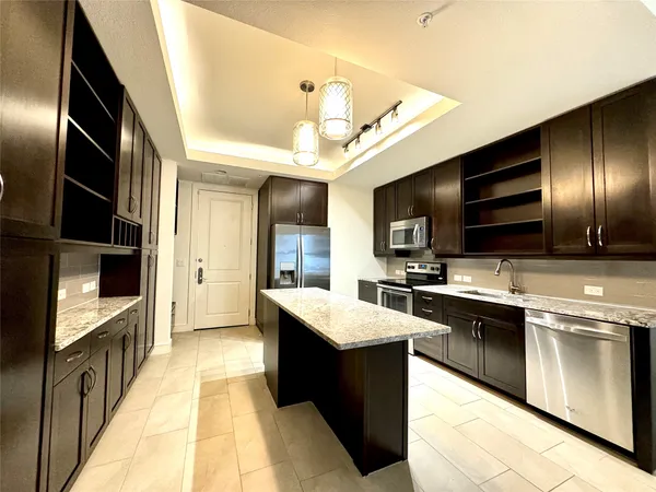 a large kitchen with stainless steel appliances kitchen island granite countertop a large counter top cabinets and stainless steel appliances