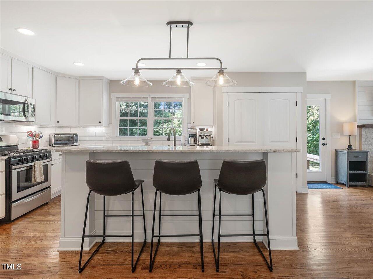 1310 Carolina Pines Avenue Raleigh, NC 27603 - Photo 16 of 53 a kitchen with stainless steel appliances a stove a sink and a refrigerator with wooden floor