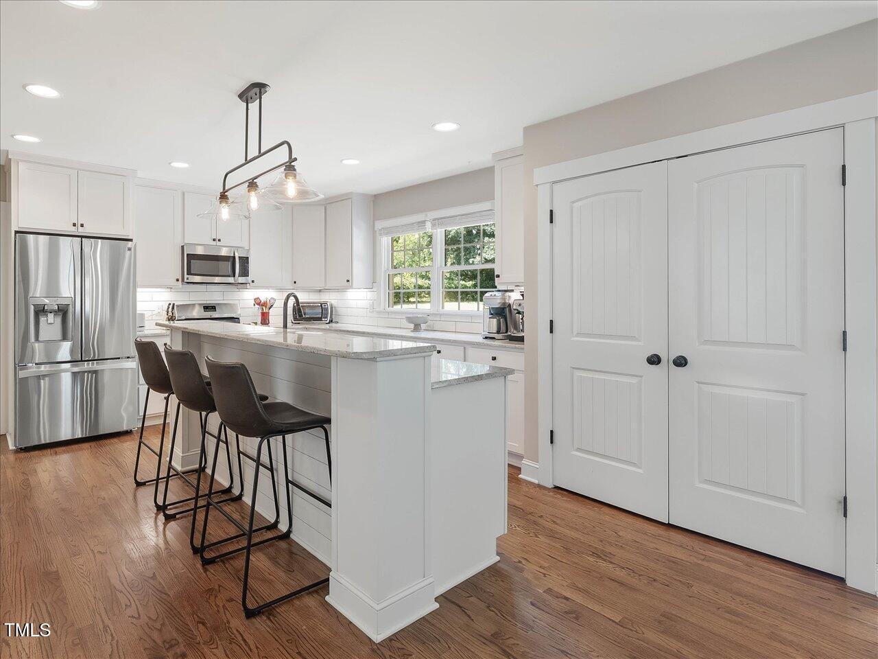 1310 Carolina Pines Avenue Raleigh, NC 27603 - Photo 17 of 53 a kitchen with kitchen island white cabinets and stainless steel appliances