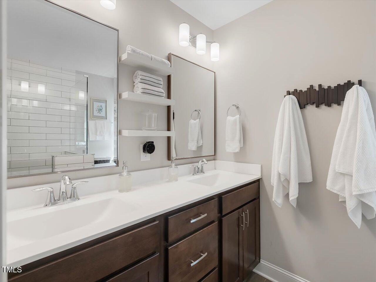 1310 Carolina Pines Avenue Raleigh, NC 27603 - Photo 34 of 53 a bathroom with a double vanity sink a and a mirror