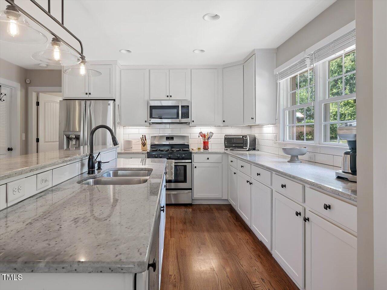 1310 Carolina Pines Avenue Raleigh, NC 27603 - Photo 4 of 53 a kitchen with kitchen island granite countertop a sink appliances cabinets and a window
