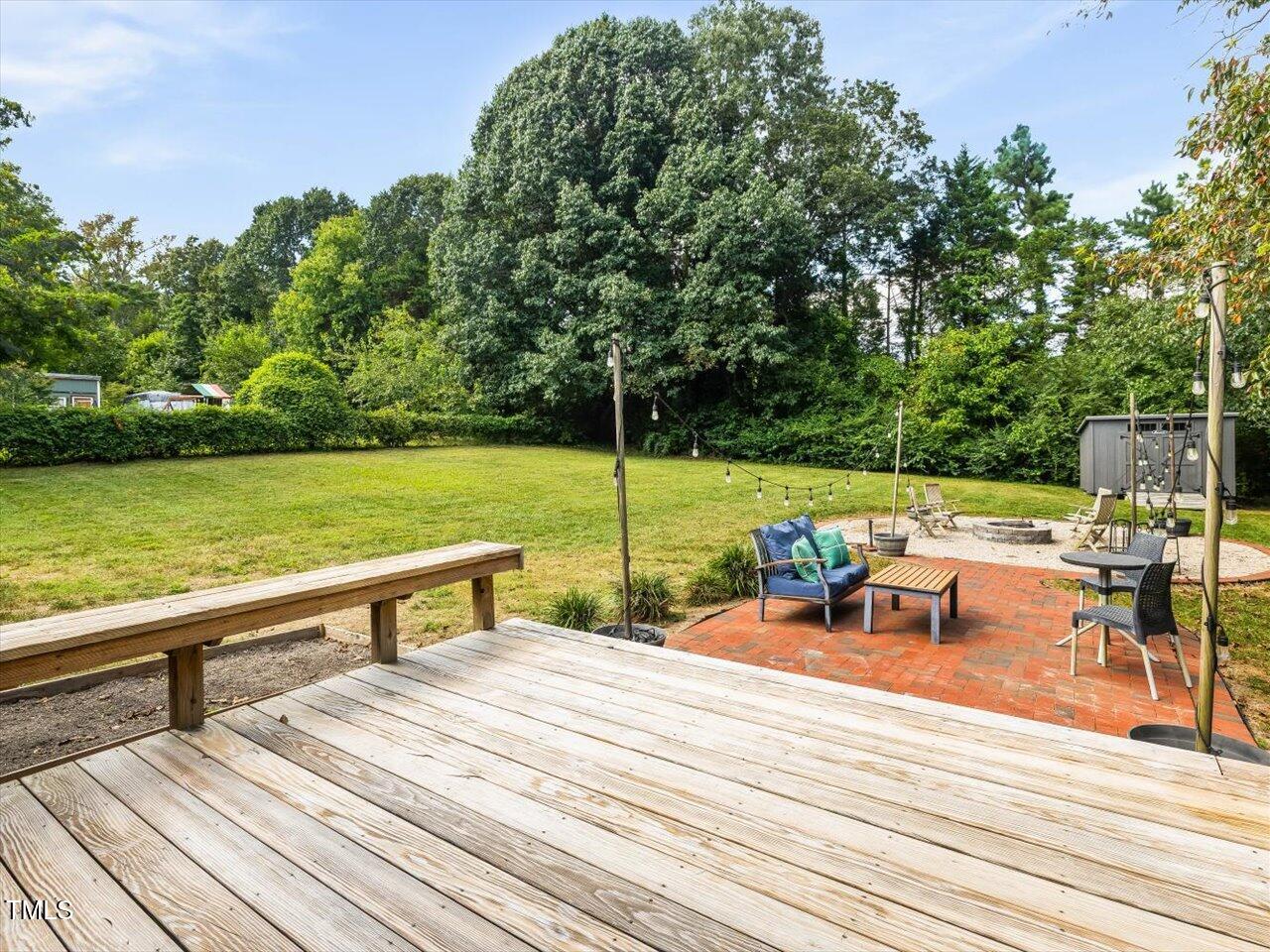 1310 Carolina Pines Avenue Raleigh, NC 27603 - Photo 7 of 53 a view of a patio with dining table and chairs with wooden floor and fence