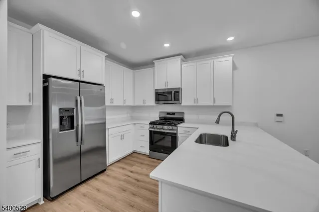 a kitchen with kitchen island a sink stainless steel appliances and cabinets