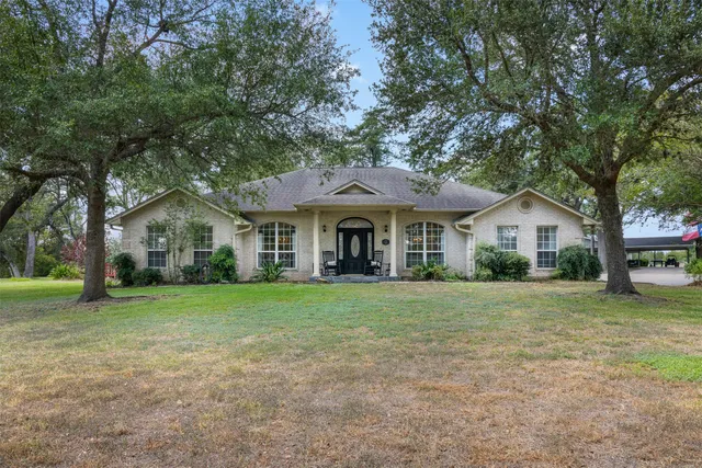 a front view of a house with a yard and trees