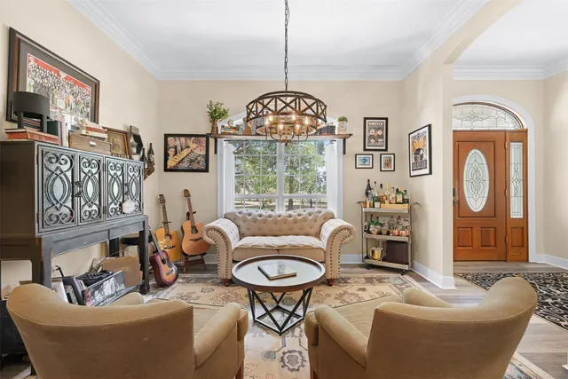 a living room with furniture chandelier and a large window