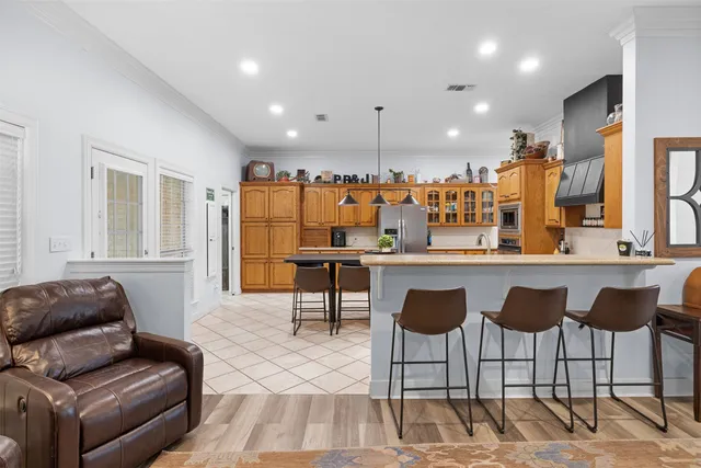 a kitchen with stainless steel appliances kitchen island granite countertop a refrigerator and a stove top oven