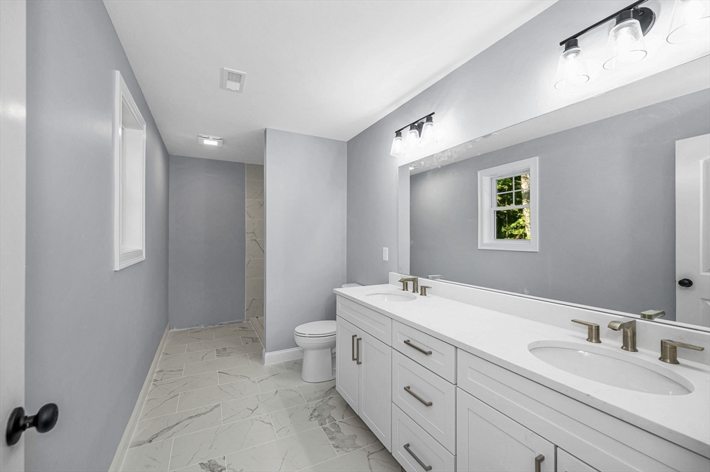 17 Norris Road Tyngsborough, MA 01879 - Photo 32 of 42 a spacious bathroom with a double vanity sink mirror and toilet
