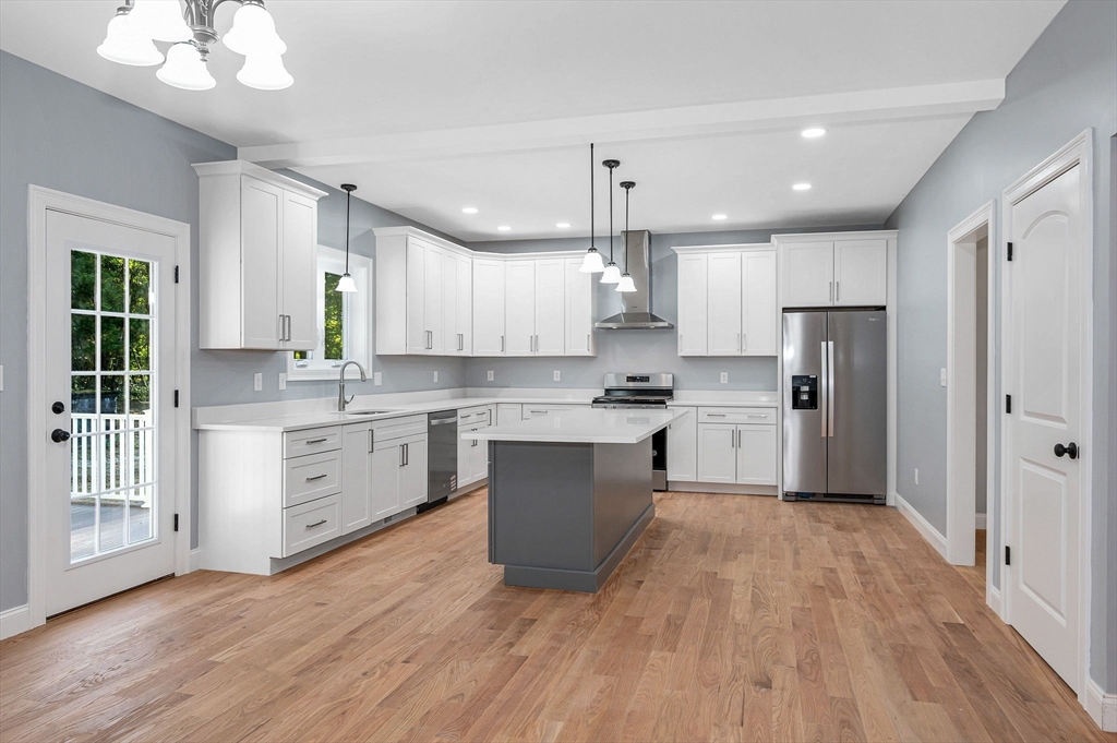 17 Norris Road Tyngsborough, MA 01879 - Photo 10 of 42 a large kitchen with cabinets wooden floor stainless steel appliances and a window