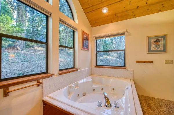 a bathroom with a granite countertop sink mirror vanity and a bathtub