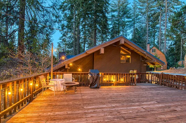 a view of a roof deck with table and chairs a barbeque with wooden floor and fence