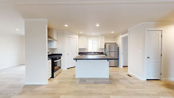 a kitchen with kitchen island stainless steel appliances a sink stove and refrigerator