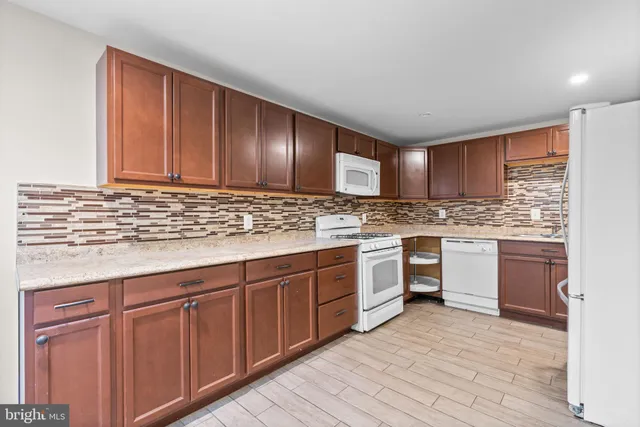 a kitchen with stainless steel appliances granite countertop a stove cabinets and wooden floor