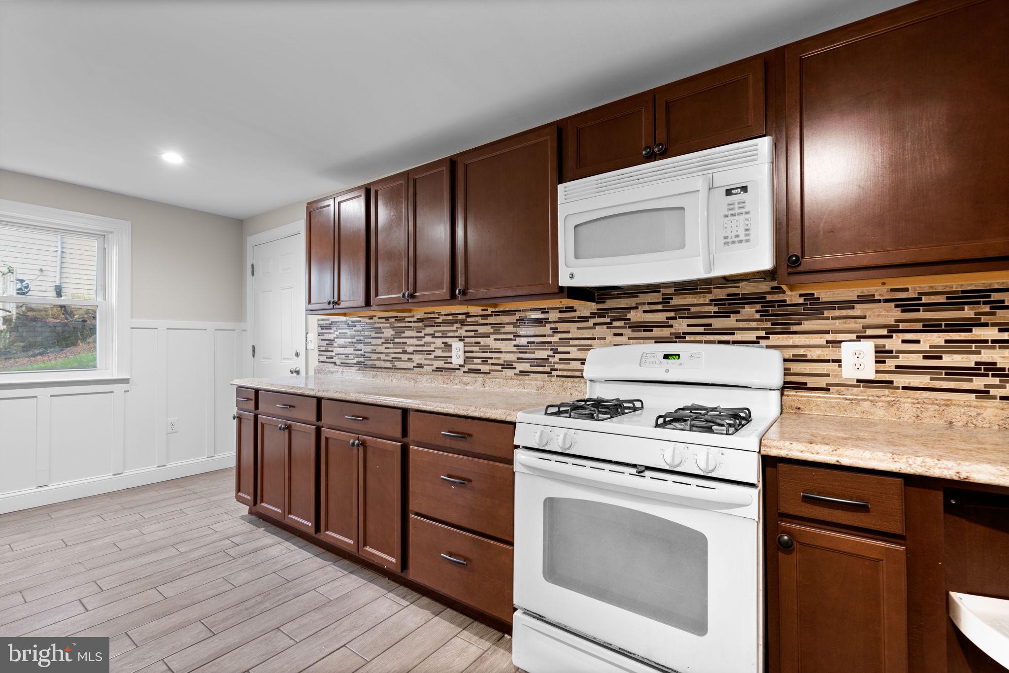8483 Frederick Road Ellicott City, MD 21043 - Photo 15 of 44 a kitchen with cabinets wooden floor and a sink
