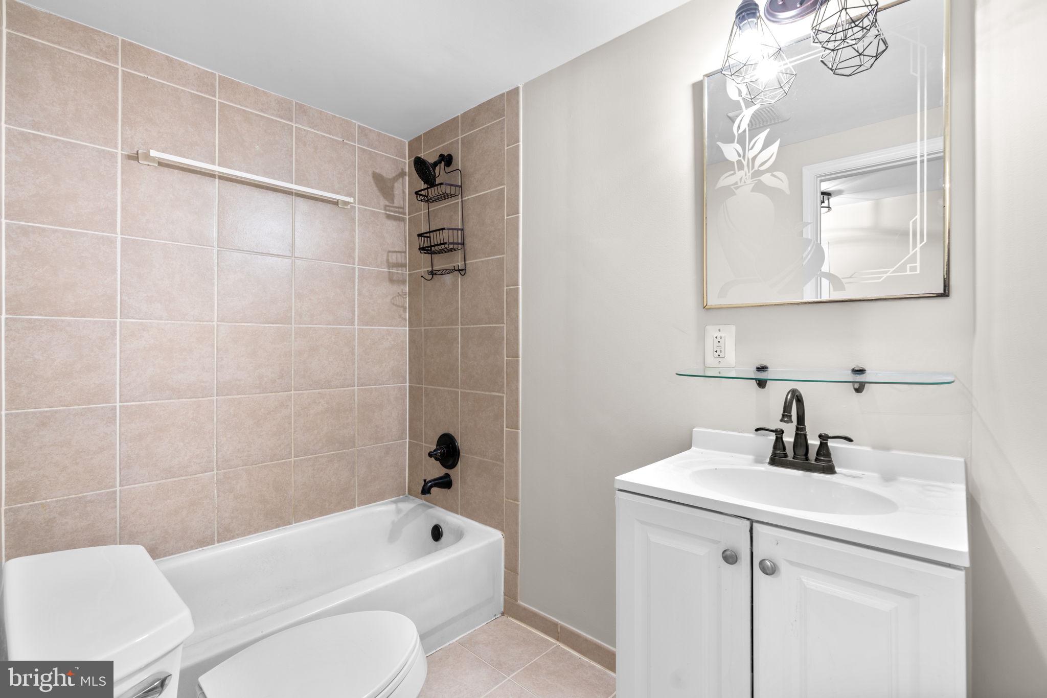 8483 Frederick Road Ellicott City, MD 21043 - Photo 29 of 44 a bathroom with a sink a toilet and shower