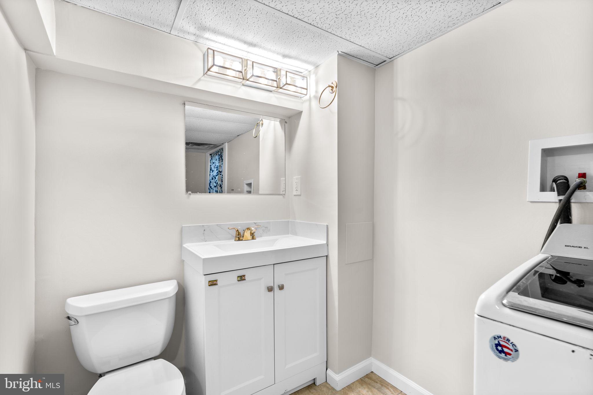 8483 Frederick Road Ellicott City, MD 21043 - Photo 34 of 44 a bathroom with a toilet a sink and mirror