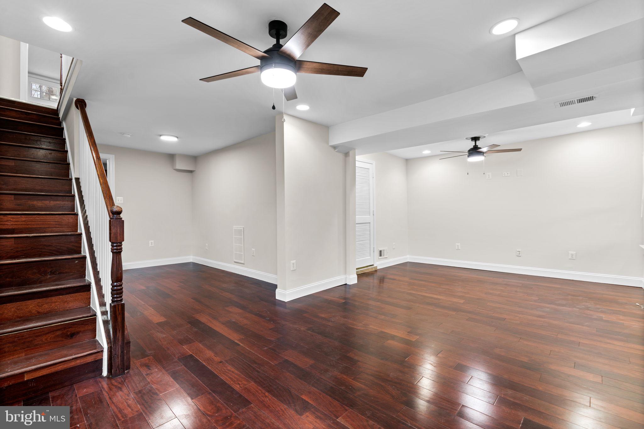 8483 Frederick Road Ellicott City, MD 21043 - Photo 4 of 44 an empty room with wooden floor fan and windows