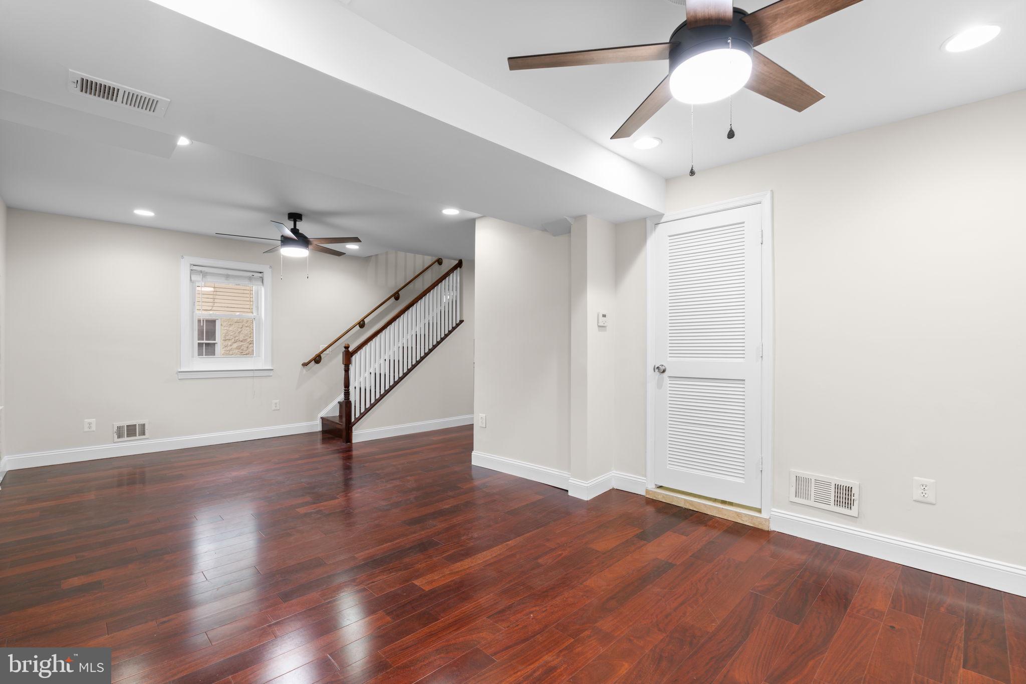 8483 Frederick Road Ellicott City, MD 21043 - Photo 8 of 44 an empty room with wooden floor and ceiling fan