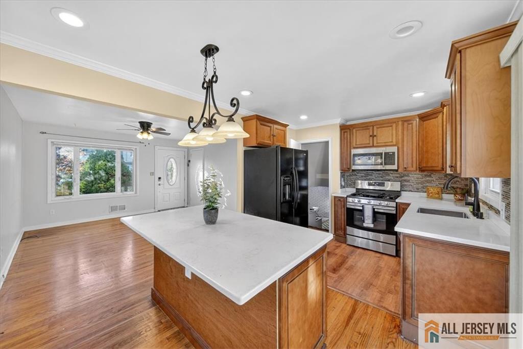 6 Dundar Road Edison, NJ 08817 - Photo 7 of 22 a kitchen with stainless steel appliances kitchen island granite countertop a refrigerator a oven a sink with island and chairs