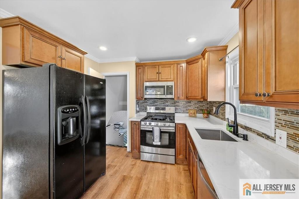 6 Dundar Road Edison, NJ 08817 - Photo 8 of 22 a kitchen with stainless steel appliances granite countertop a refrigerator a stove and a sink with wooden floor