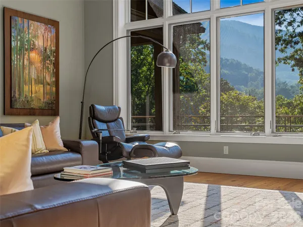 a view of a patio with table and chairs potted plants with floor to ceiling window