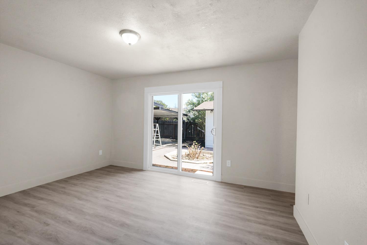 2832 Fowler Road Ceres, CA 95307 - Photo 12 of 28 an empty room with wooden floor and windows