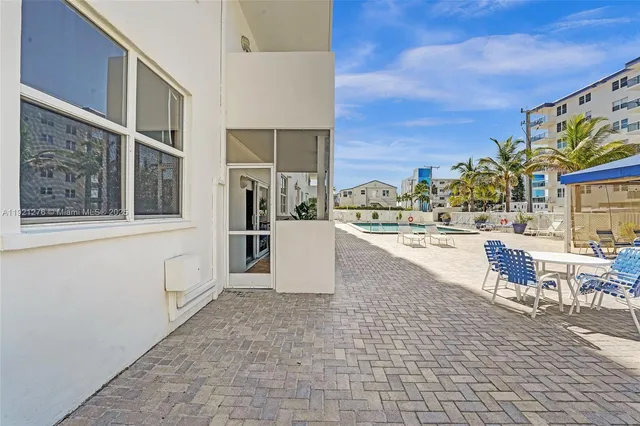 a view of a patio with a table and chairs and potted plants