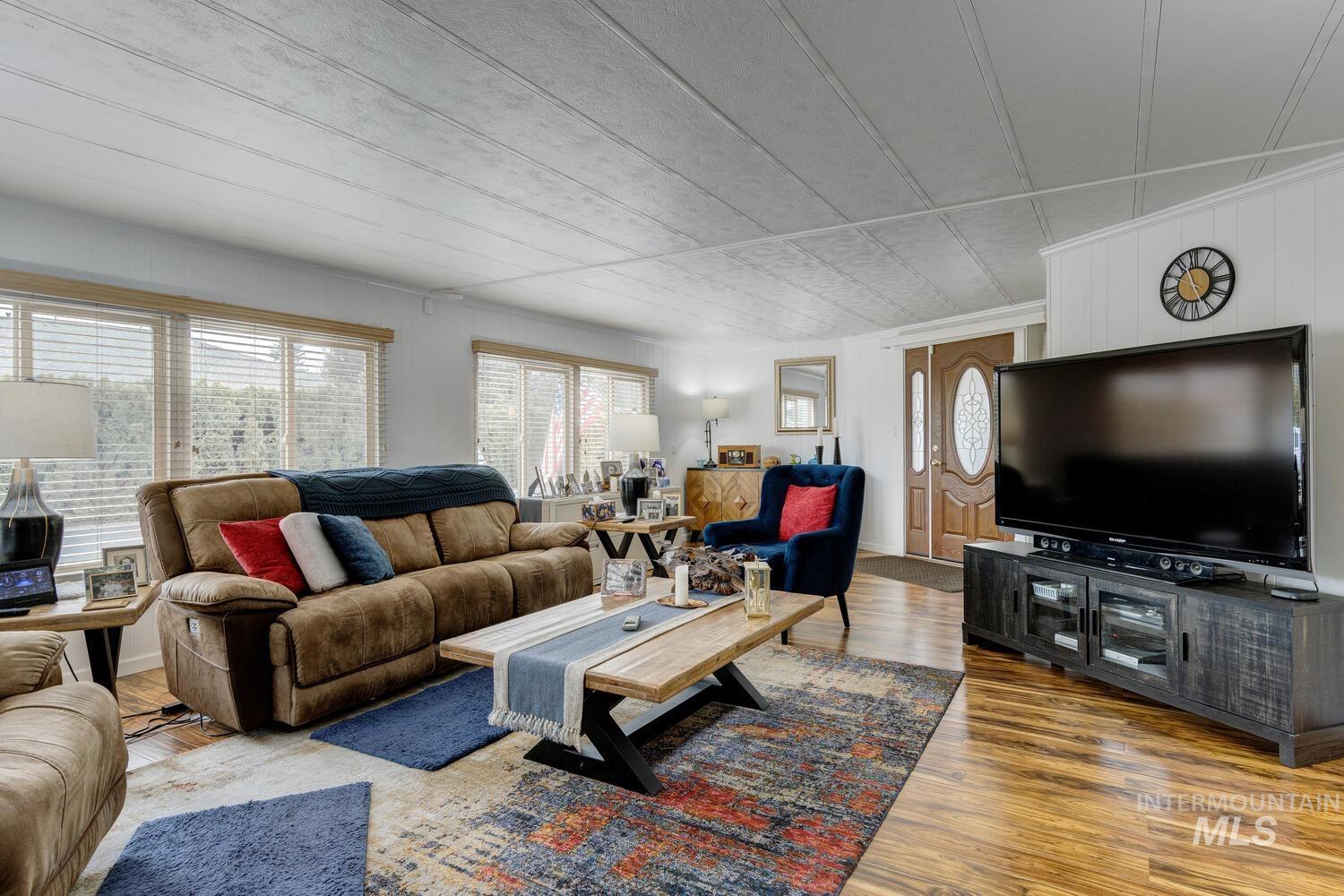 9390 West Ustick Road, Unit 64 Boise, ID 83704 - Photo 9 of 36 Living room with healthy amount of natural light, wood finished floors, and crown molding