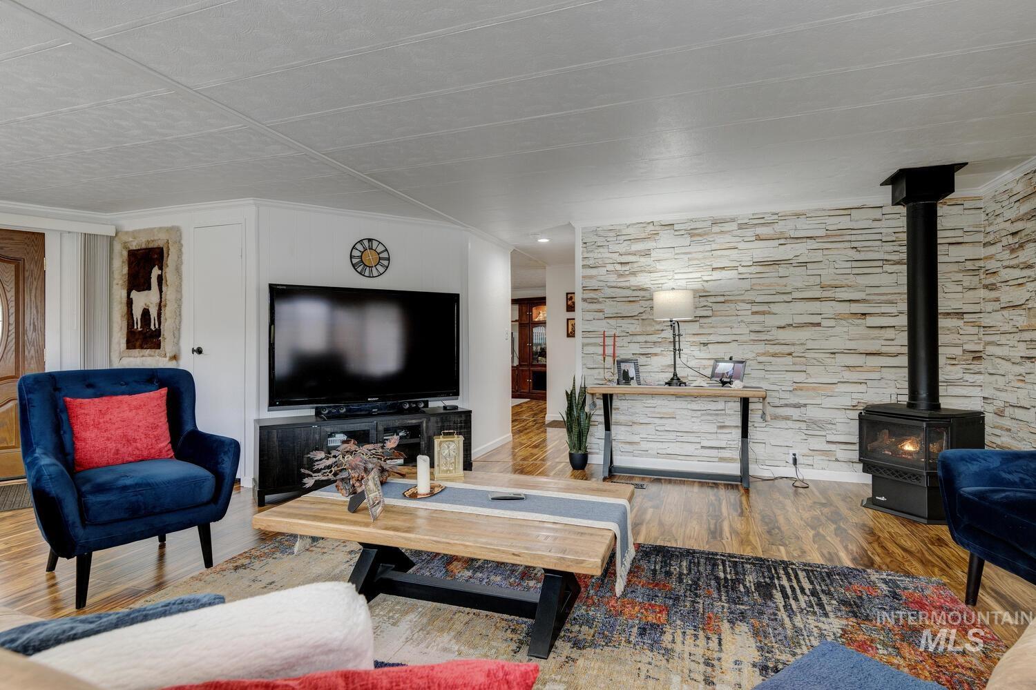 9390 West Ustick Road, Unit 64 Boise, ID 83704 - Photo 10 of 36 Living room with a wood stove, wood finished floors, and ornamental molding