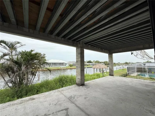 a porch with a floor to ceiling window next to a yard