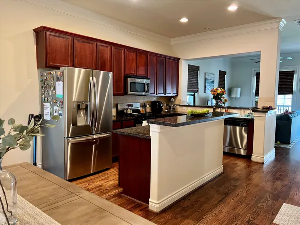a kitchen with kitchen island a counter top space a sink a refrigerator and a stove