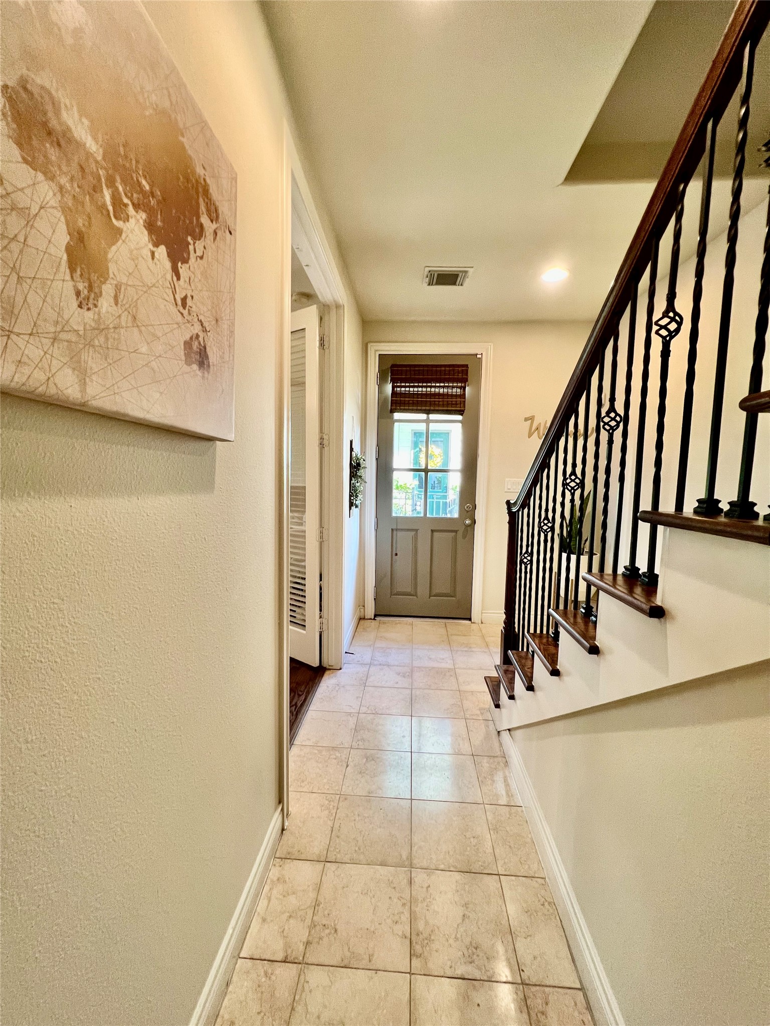 3255 Maxroy Street Houston, TX 77008 - Photo 6 of 26 A welcoming hallway with tiled flooring leads to a door with natural light.