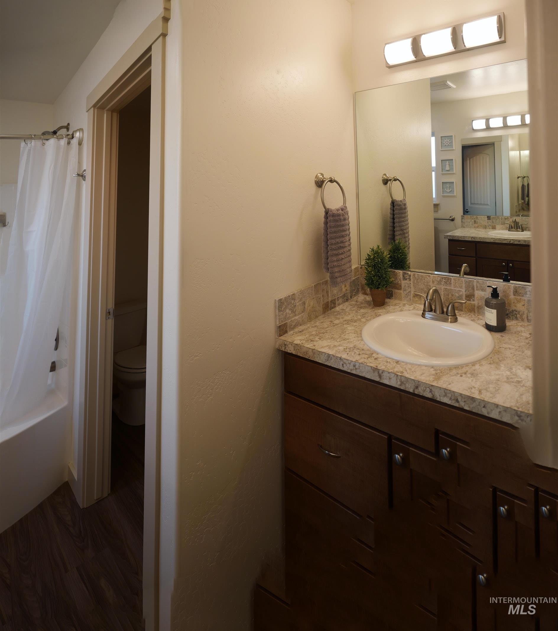178 Syringa Loop Shoshone, ID 83352 - Photo 18 of 35 Bathroom vanity featuring a light-colored countertop, undermount sink, and mosaic tile backsplash (two separate sink areas