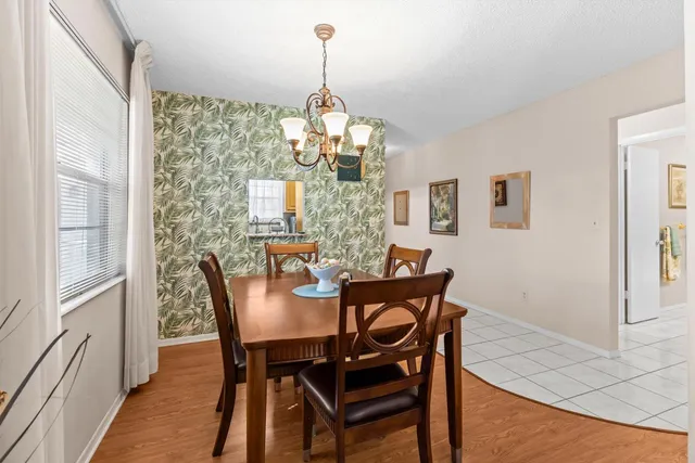 a dining room with furniture a chandelier and wooden floor